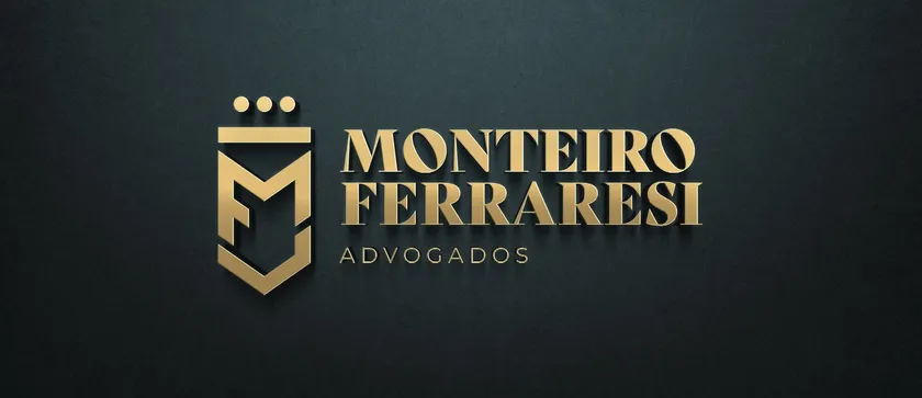 Logotipo de Monteiro Ferraresi Advogados em dourado, com um escudo com as letras MF e uma coroa de três pontos, sobre uma parede verde-escura